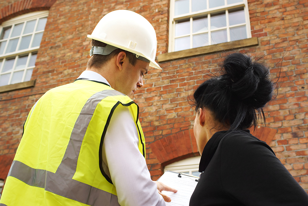 Construction worker talking to a woman