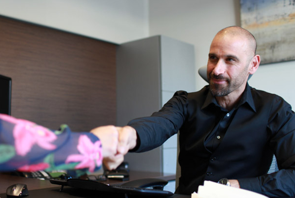 Man reaching over table shaking hand